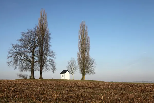 In the middle of some fields (see map), this chapel and its 3 trees are on top of a tiny hill.