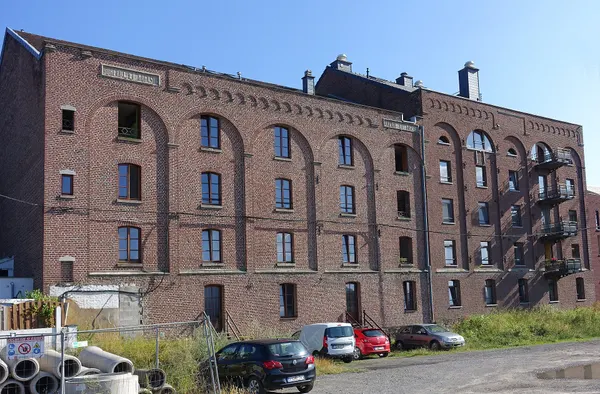 Oude gebouwen van maalderij van Union Agricole Micheroux bij het vroegere station van Micheroux, verbouwd tot appartementen