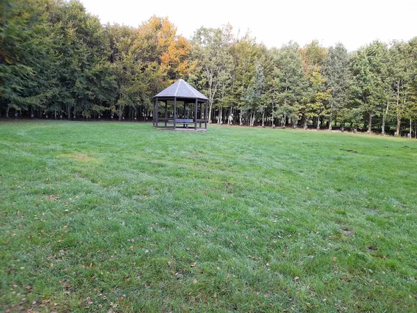 Bois de la Paix covered bench with grave stones in the background.