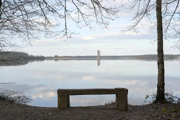 Lac de l'Eau d'Heure with Barrage de la Plate Taille visible in the background and a bench in the foreground (Froidchapelle, Belgium)