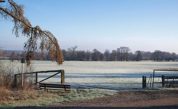 Frosty bench overlooking a frosty field along the GR-16 in Chiny, Belgium