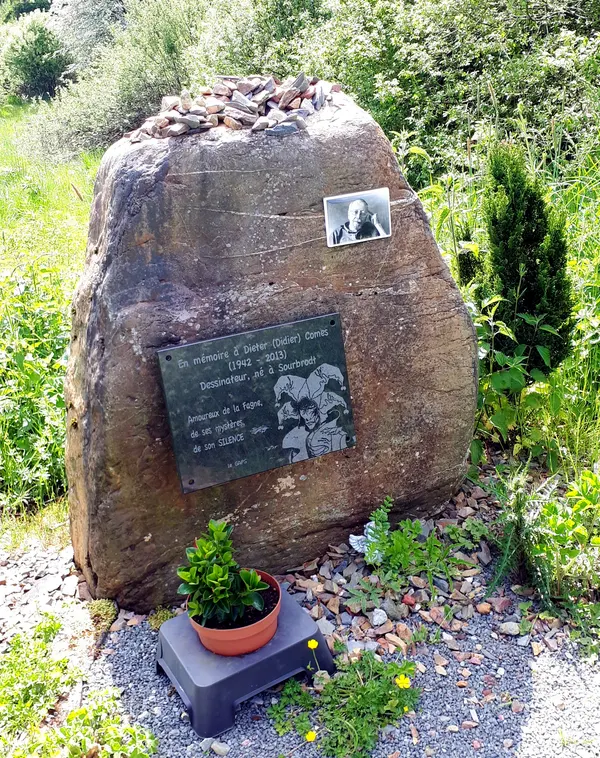 Gedenkstein mit Plakette und Porträtfoto für Didier Comes im Bosfagne bei Sourbrodt.